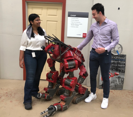 students pose next to CHIMP robot