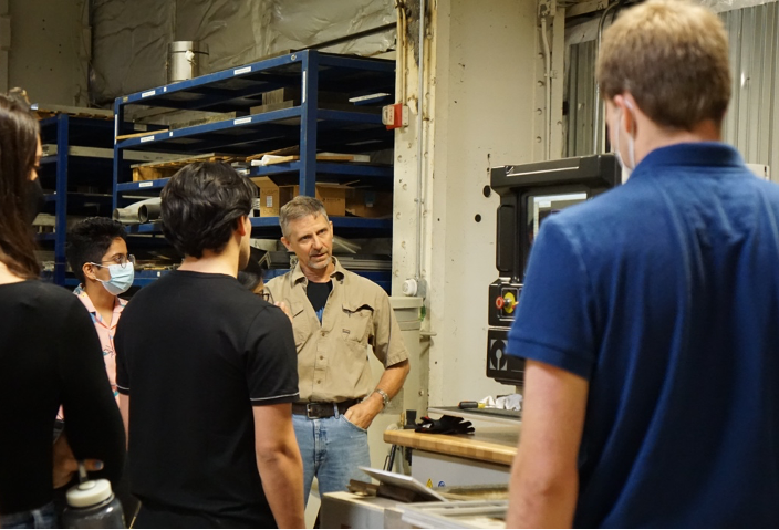 students listen to a briefing and explanation on machine shop equipment during a tour